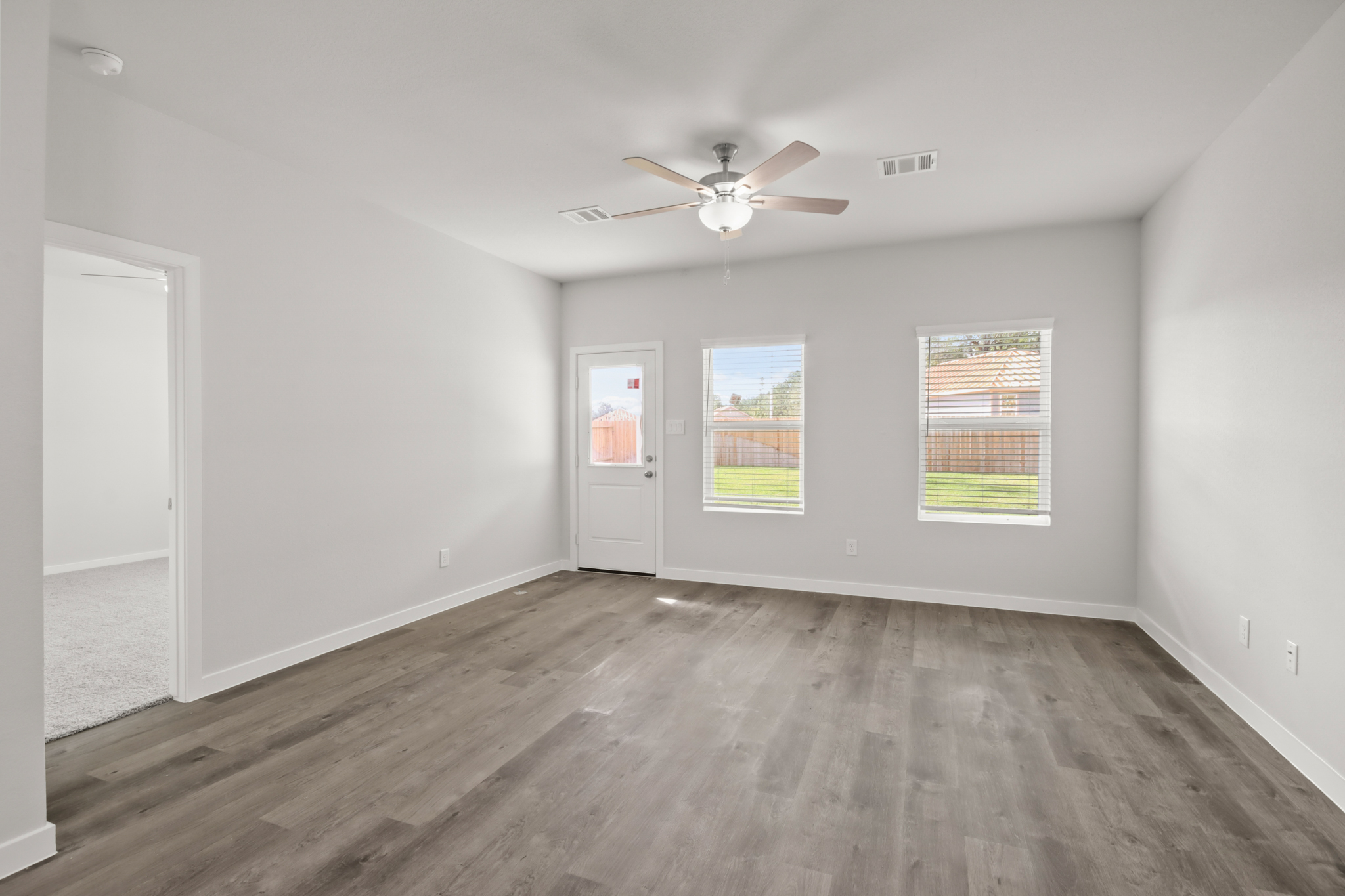 A room with a wood floor and a ceiling fan.