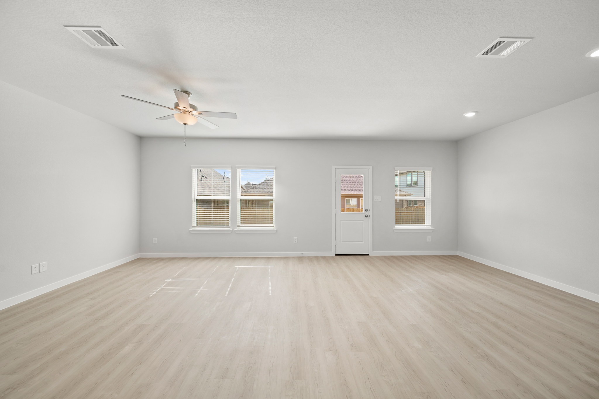 A room with a wood floor and a ceiling fan.