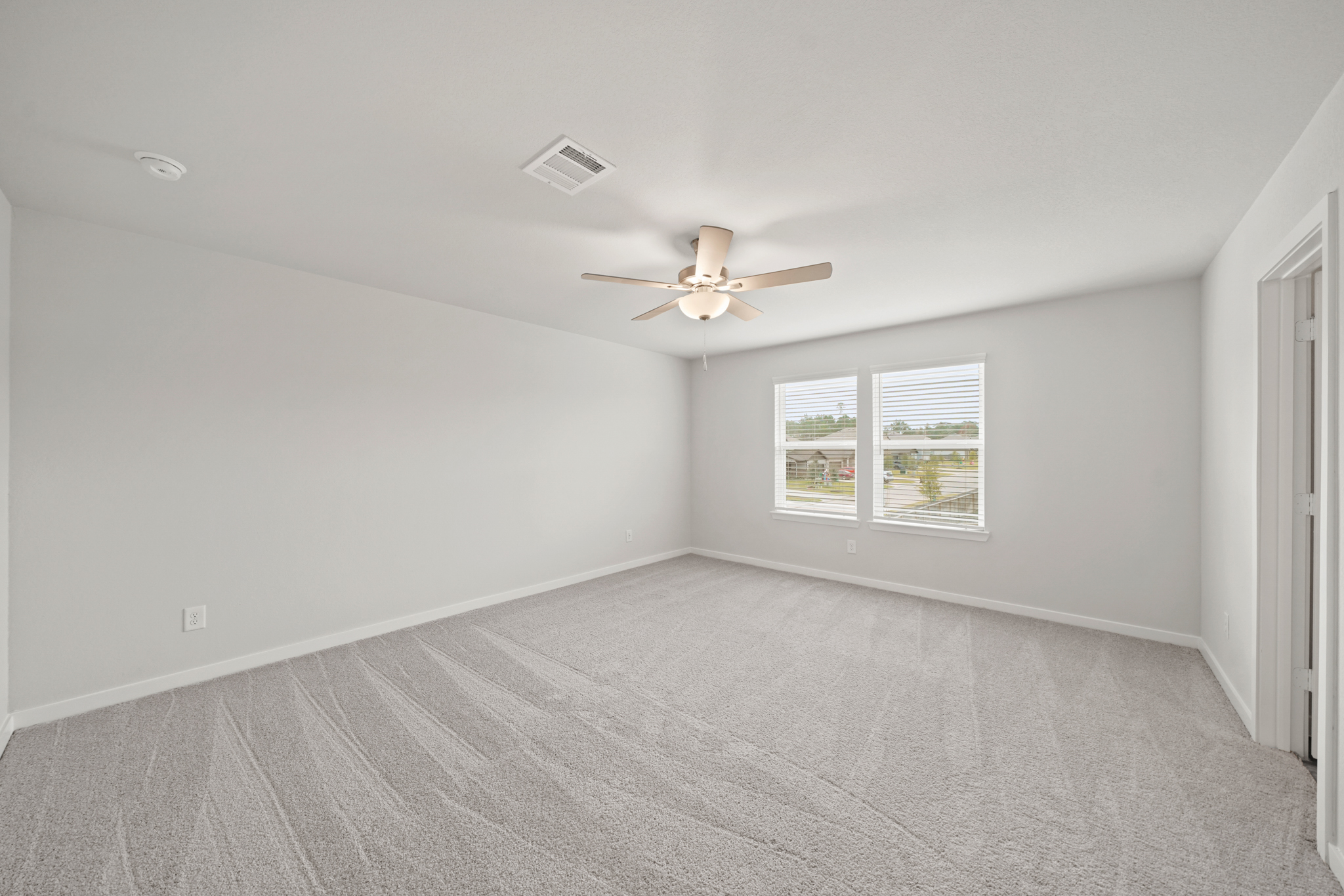 A room with a ceiling fan and a window.