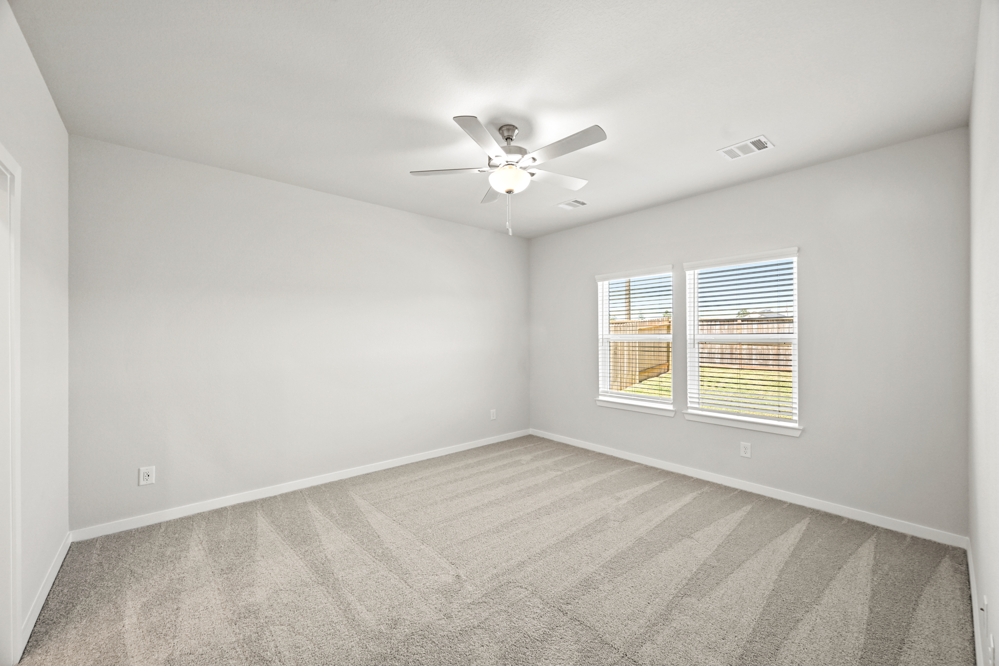 A room with a ceiling fan and a window.