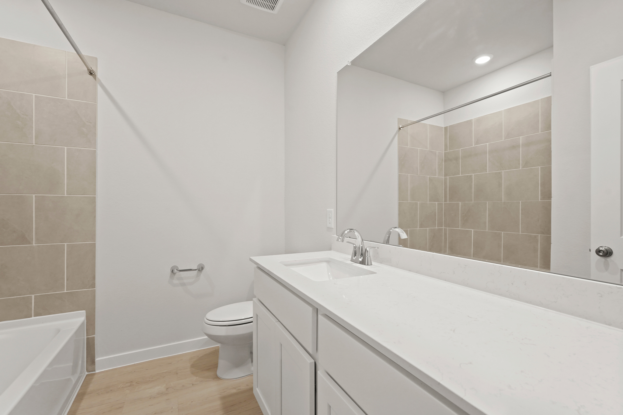 A bathroom with a large mirror.