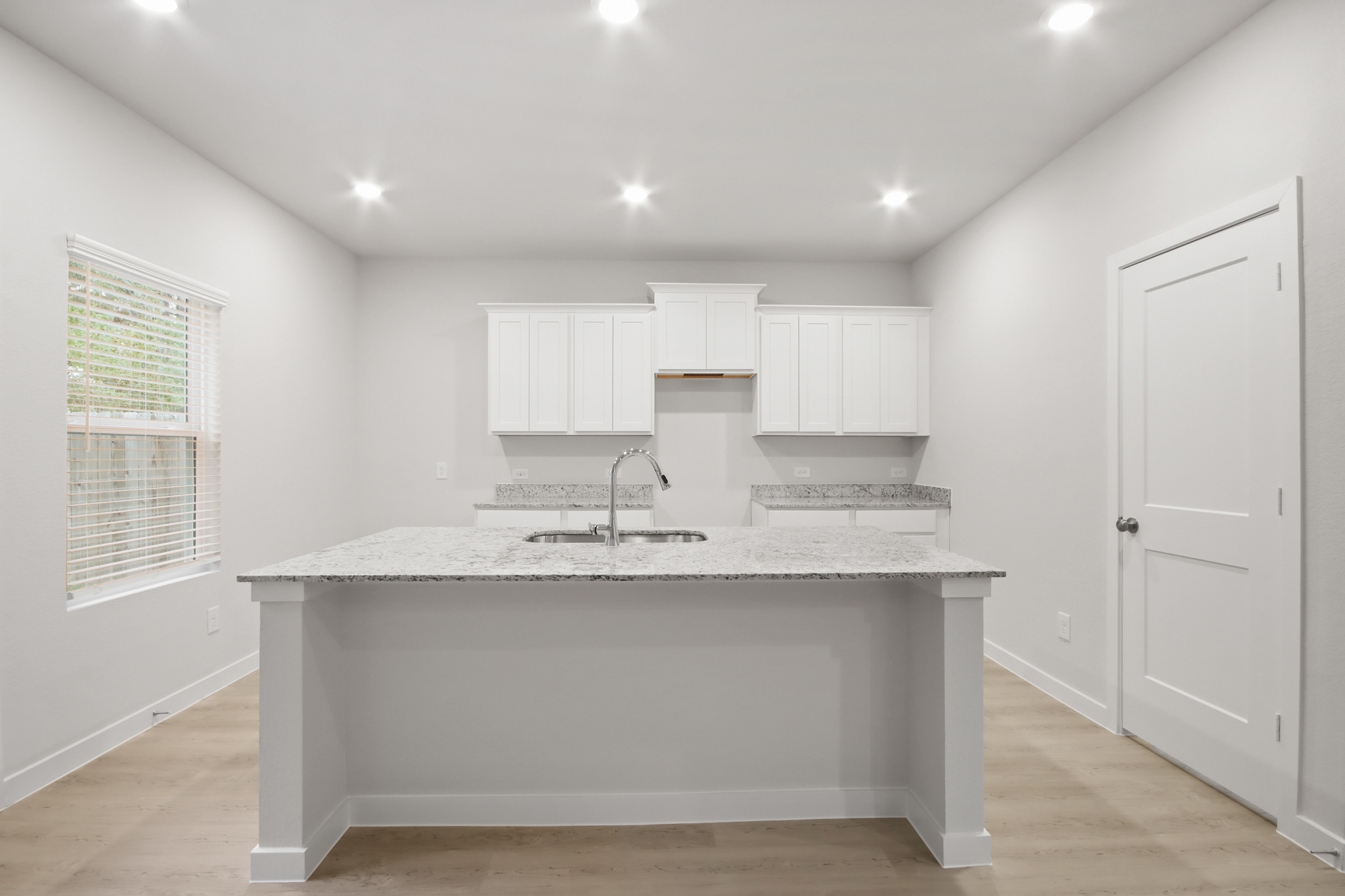 A kitchen with white cabinets.