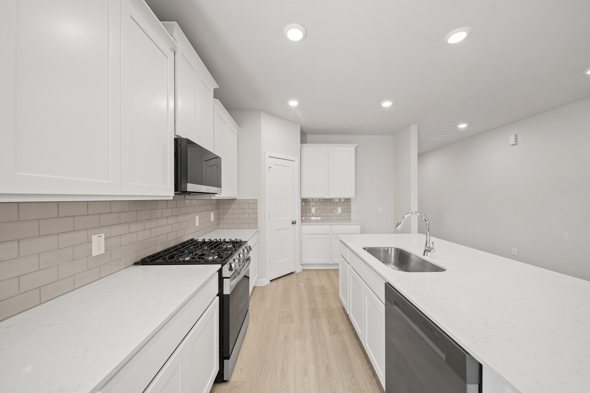 A kitchen with white cabinets.