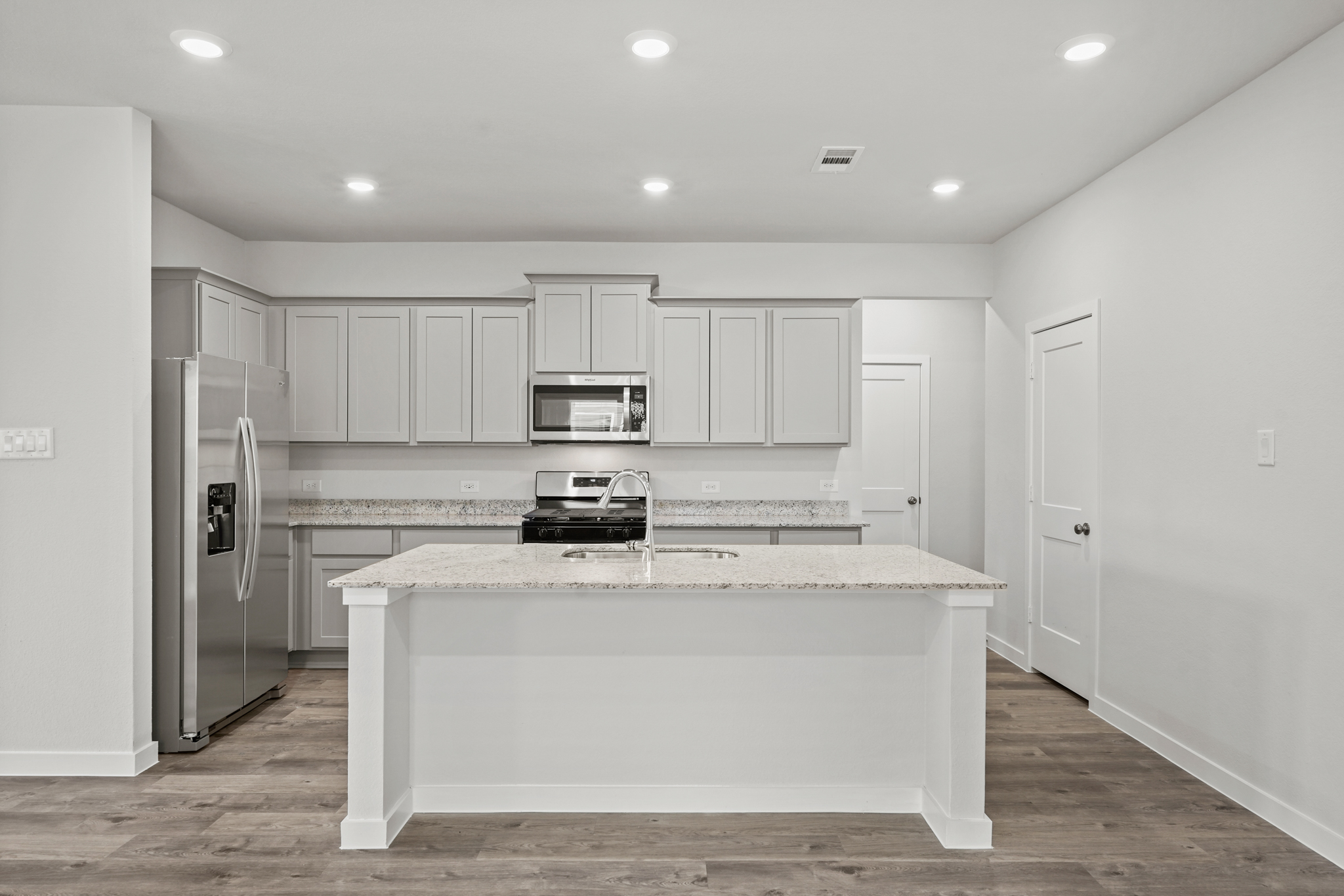 A kitchen with white cabinets.