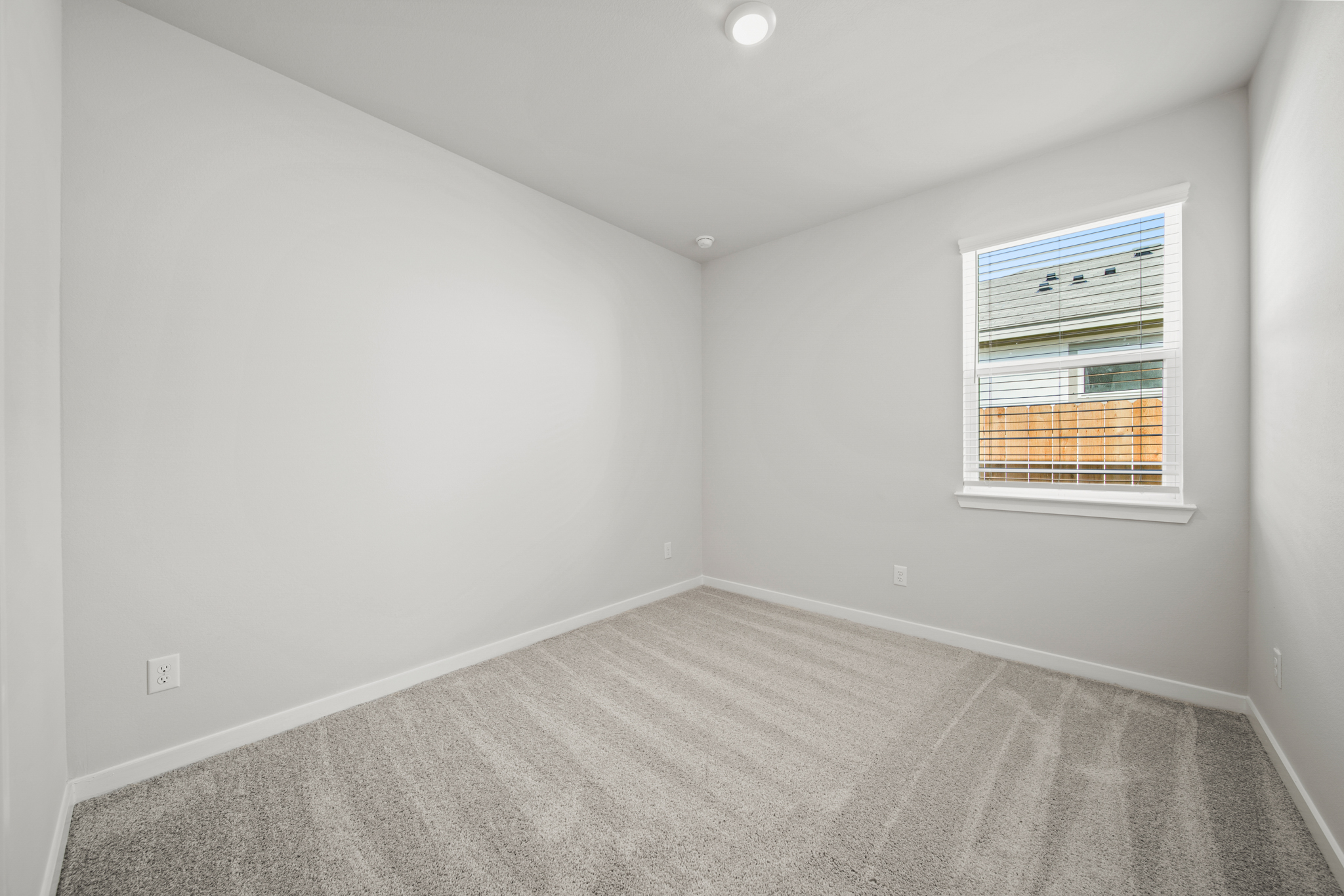 A room with a window and a carpet.