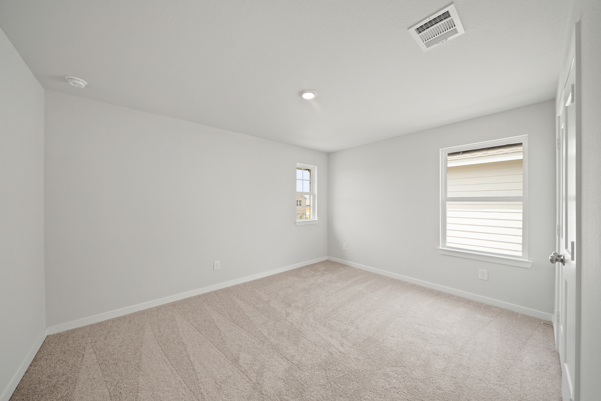 A room with a carpet and windows.