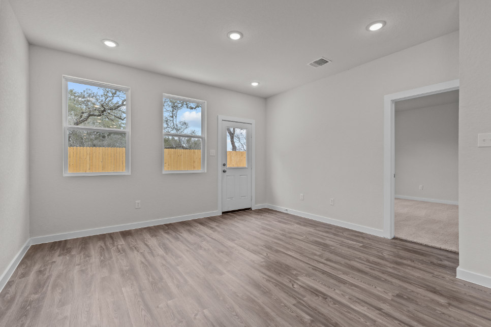 A room with a wood floor and windows.
