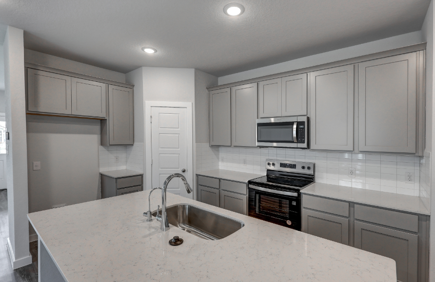 A kitchen with white cabinets.