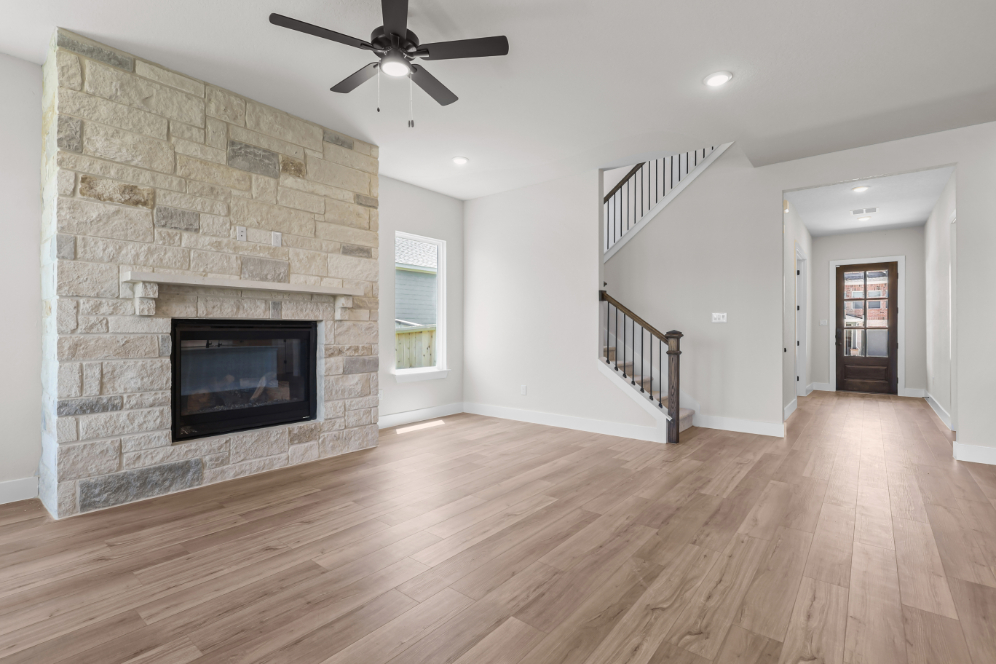 A room with a fireplace and a wood floor.