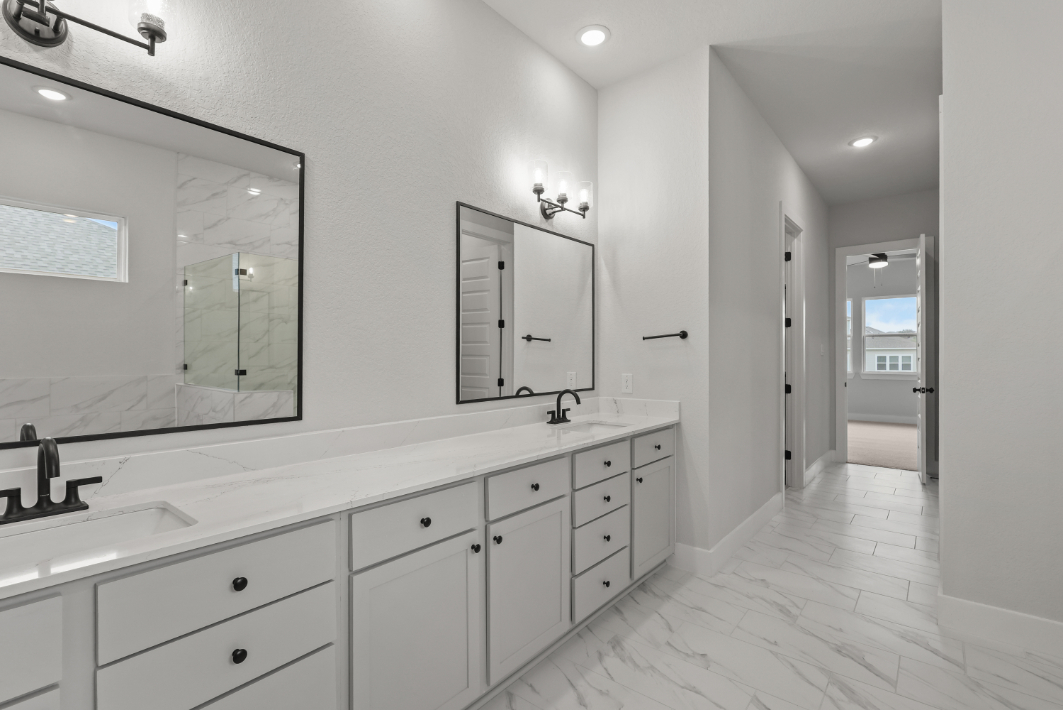 A bathroom with white cabinets.