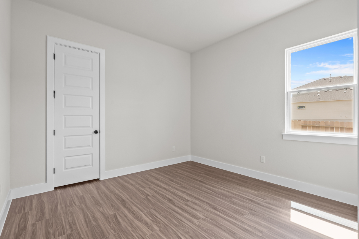 A room with a wood floor and white walls.