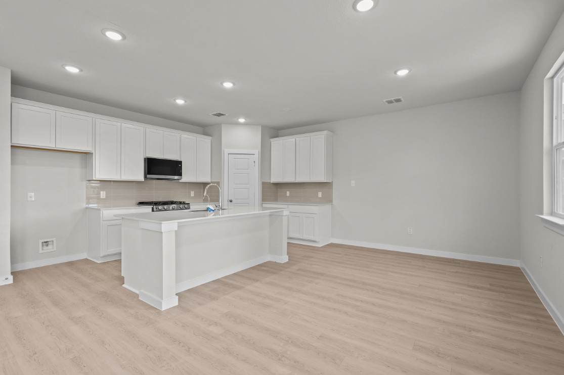 A kitchen with white cabinets.