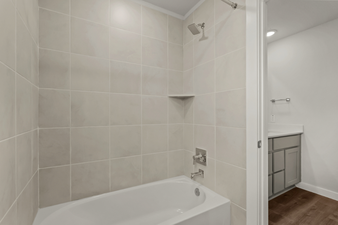 A bathroom with a bathtub and shower.