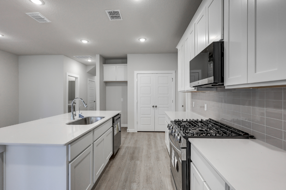 A kitchen with white cabinets.