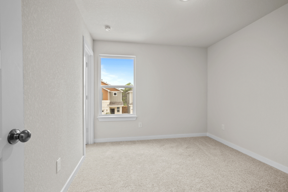 A room with a window and a carpet.