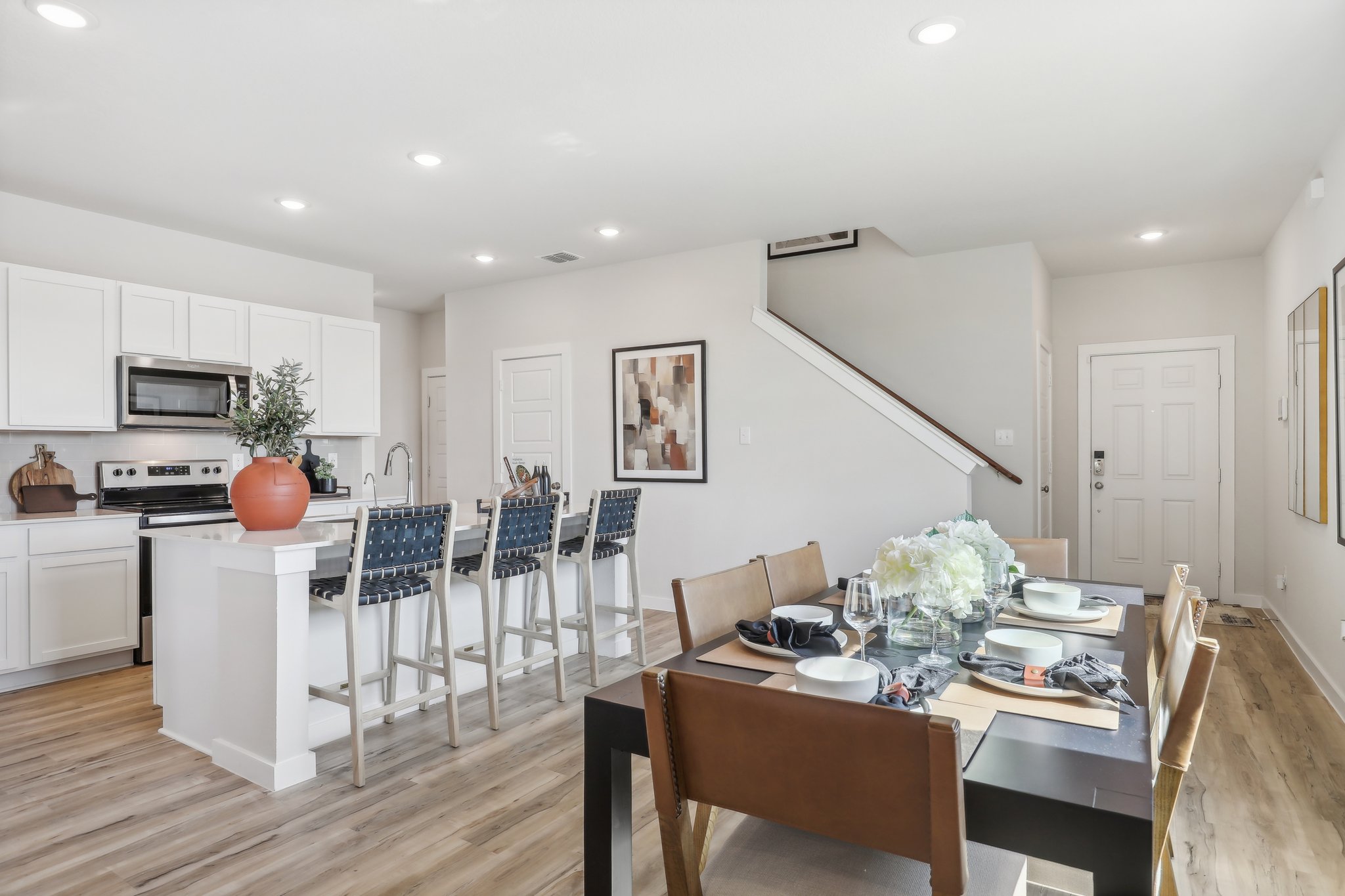 A kitchen with a dining table and chairs.