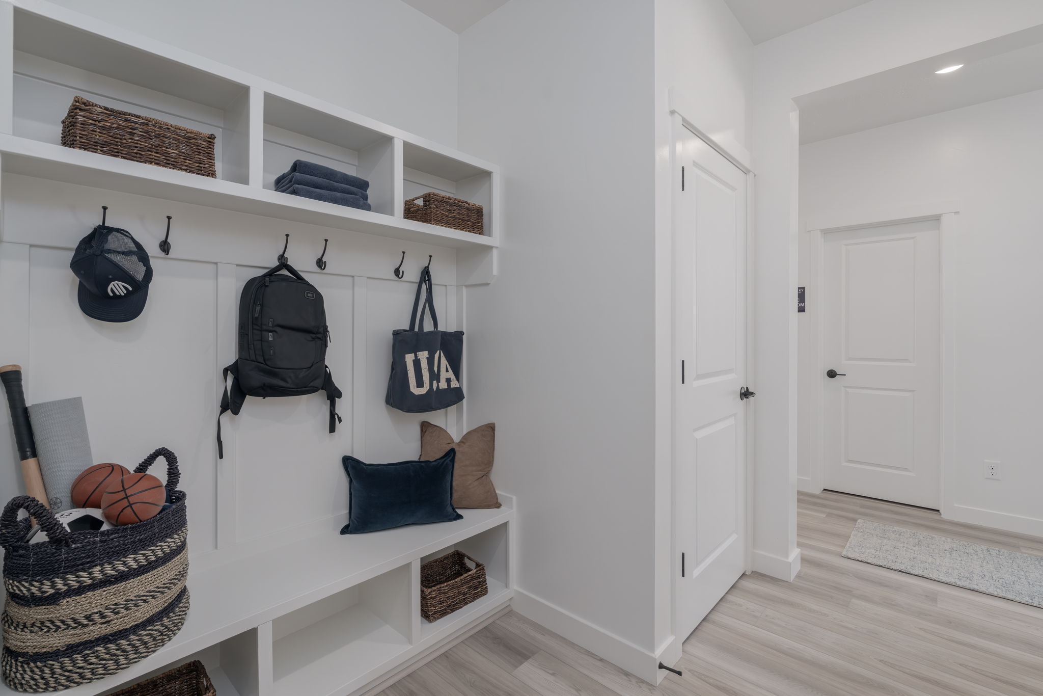 A room with a white wall and shelves with a basket and a basket.