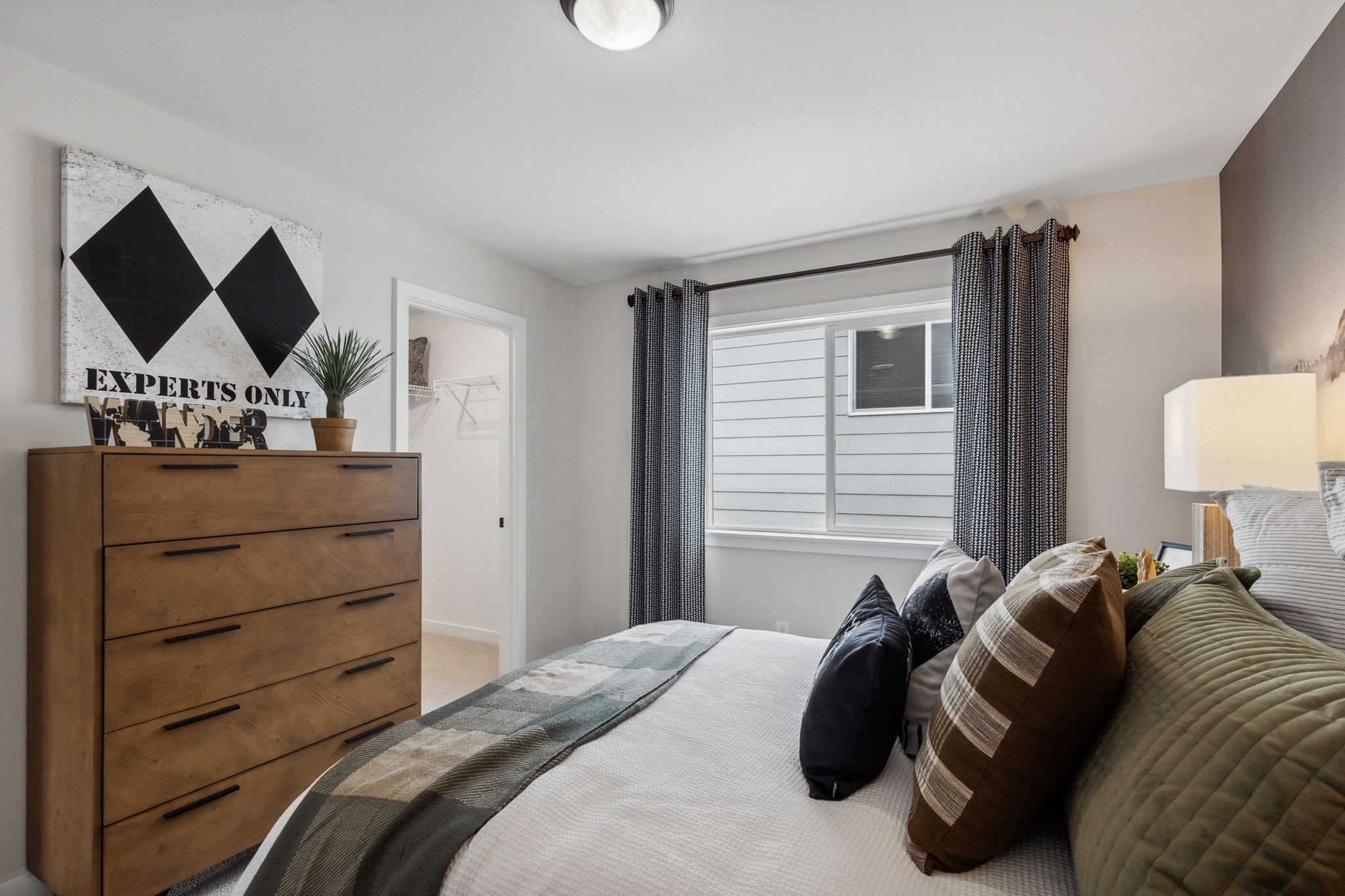 A bedroom with a bed and a dresser.
