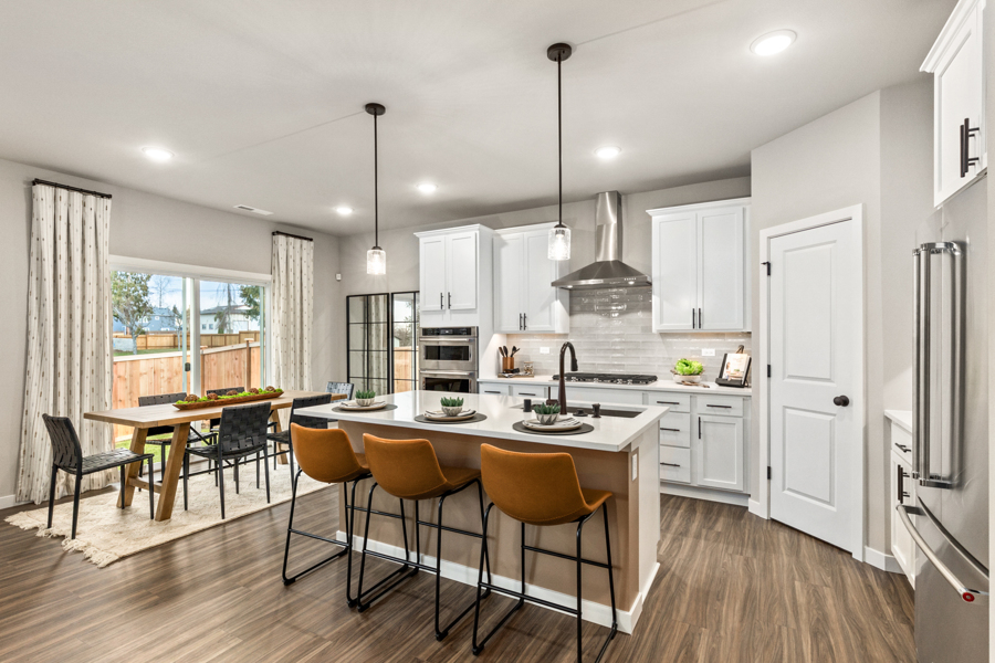 A kitchen with a dining table and chairs.