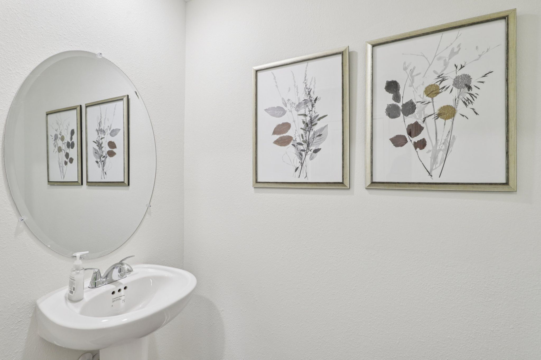 A bathroom with a couple of pictures on the wall.