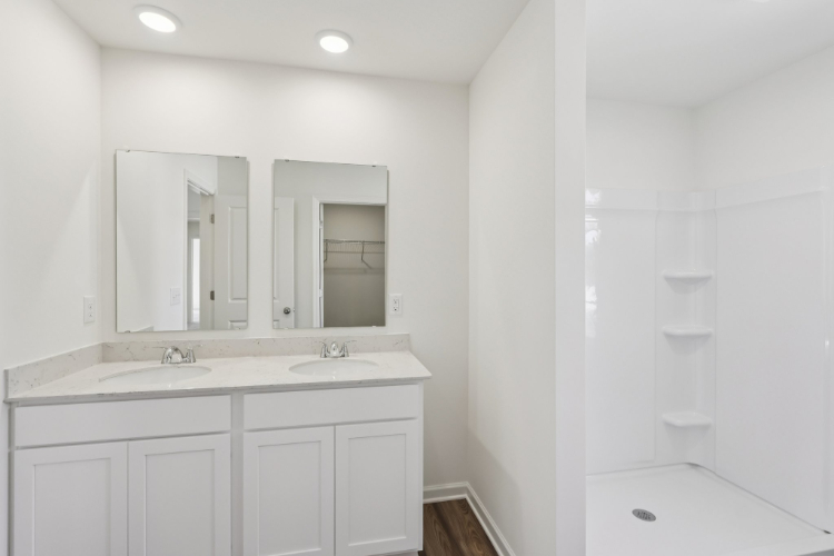 A bathroom with white cabinets.