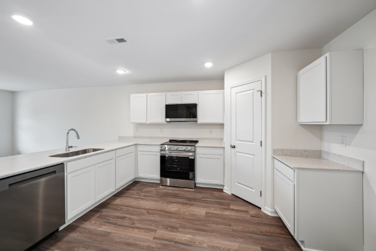 A kitchen with white cabinets.