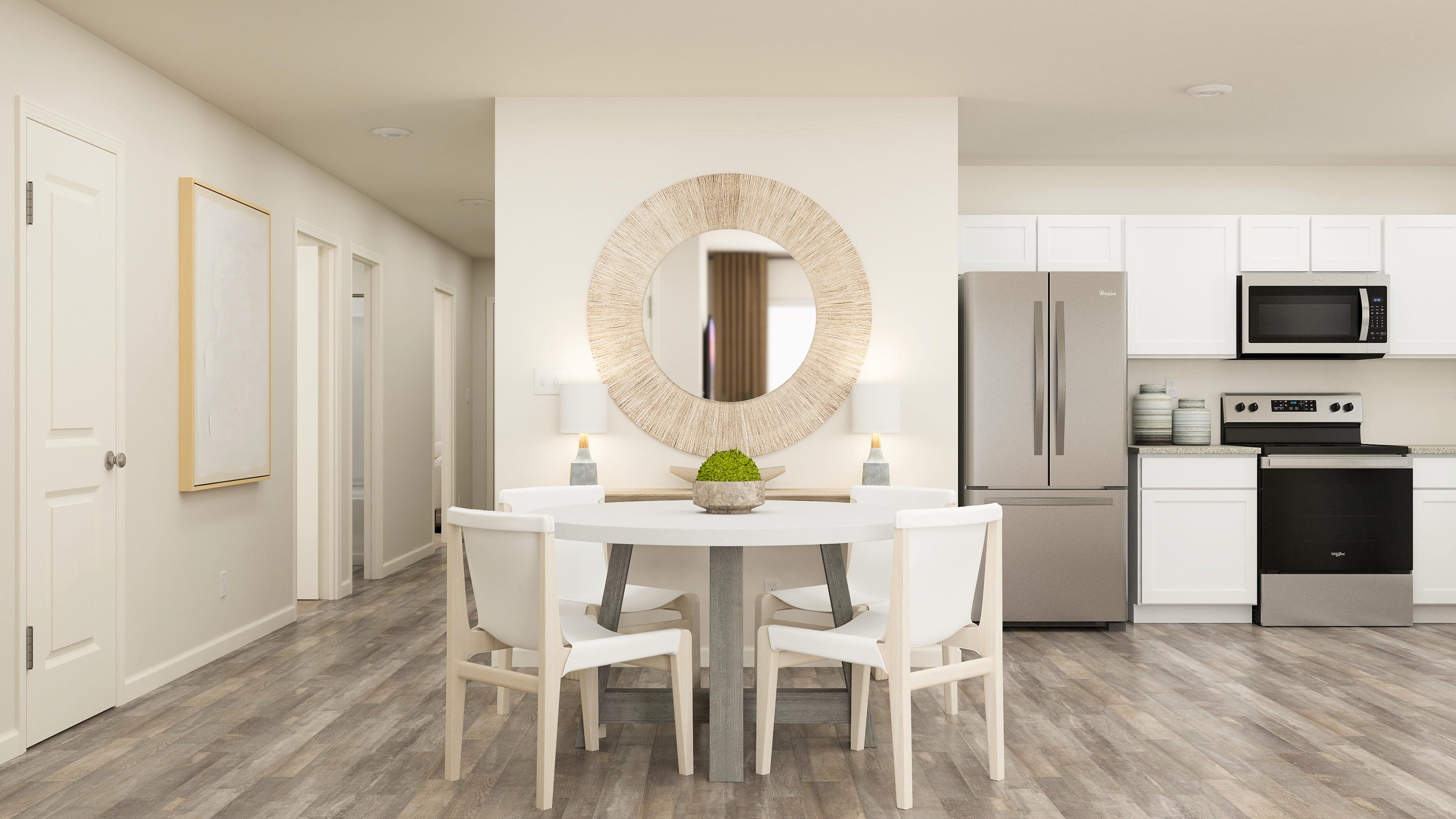 A kitchen with a dining table and white cabinets.