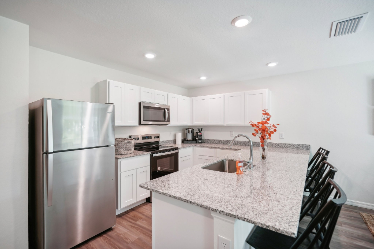 A kitchen with white cabinets.