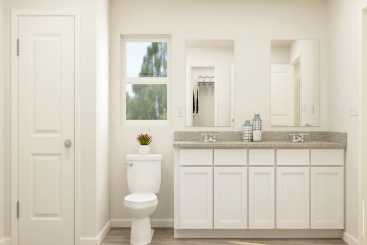 A bathroom with white cabinets.