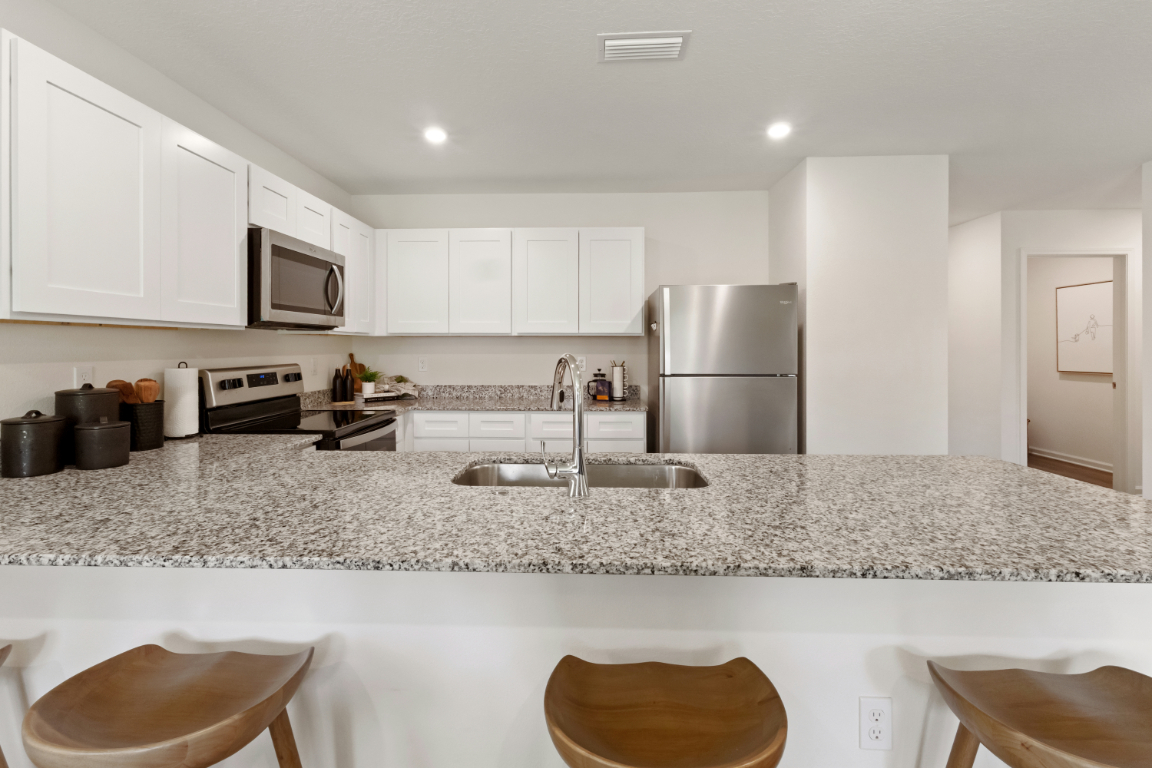 A kitchen with white cabinets.