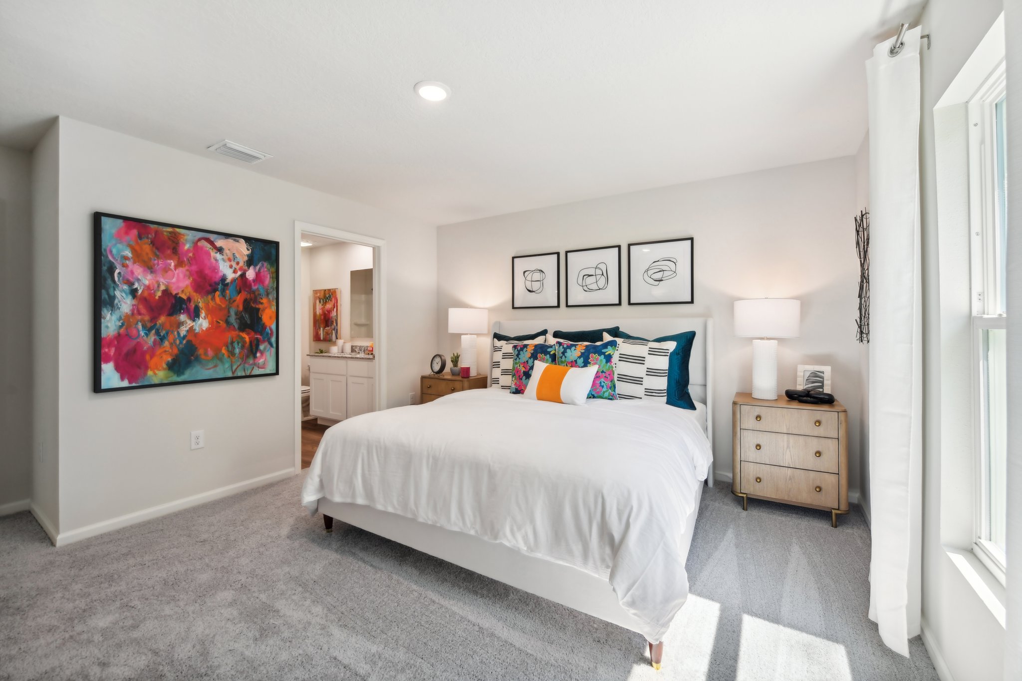 A bedroom with a bed and a lamp.