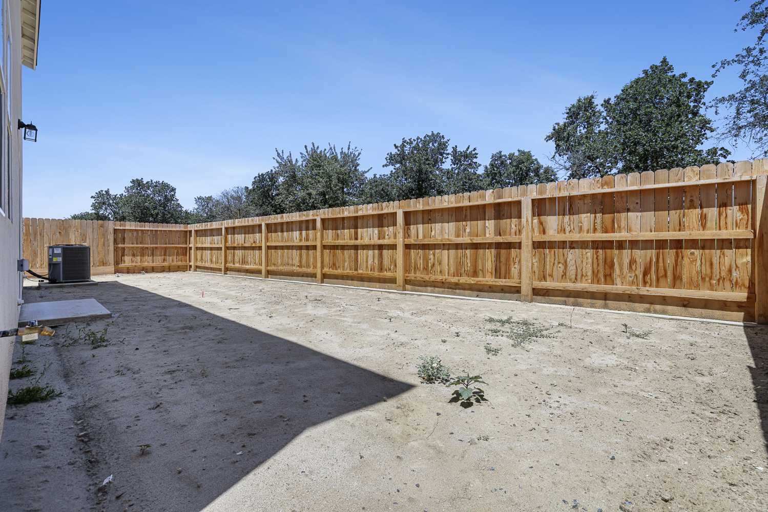 A fenced off area with a wood fence and trees in the background.
