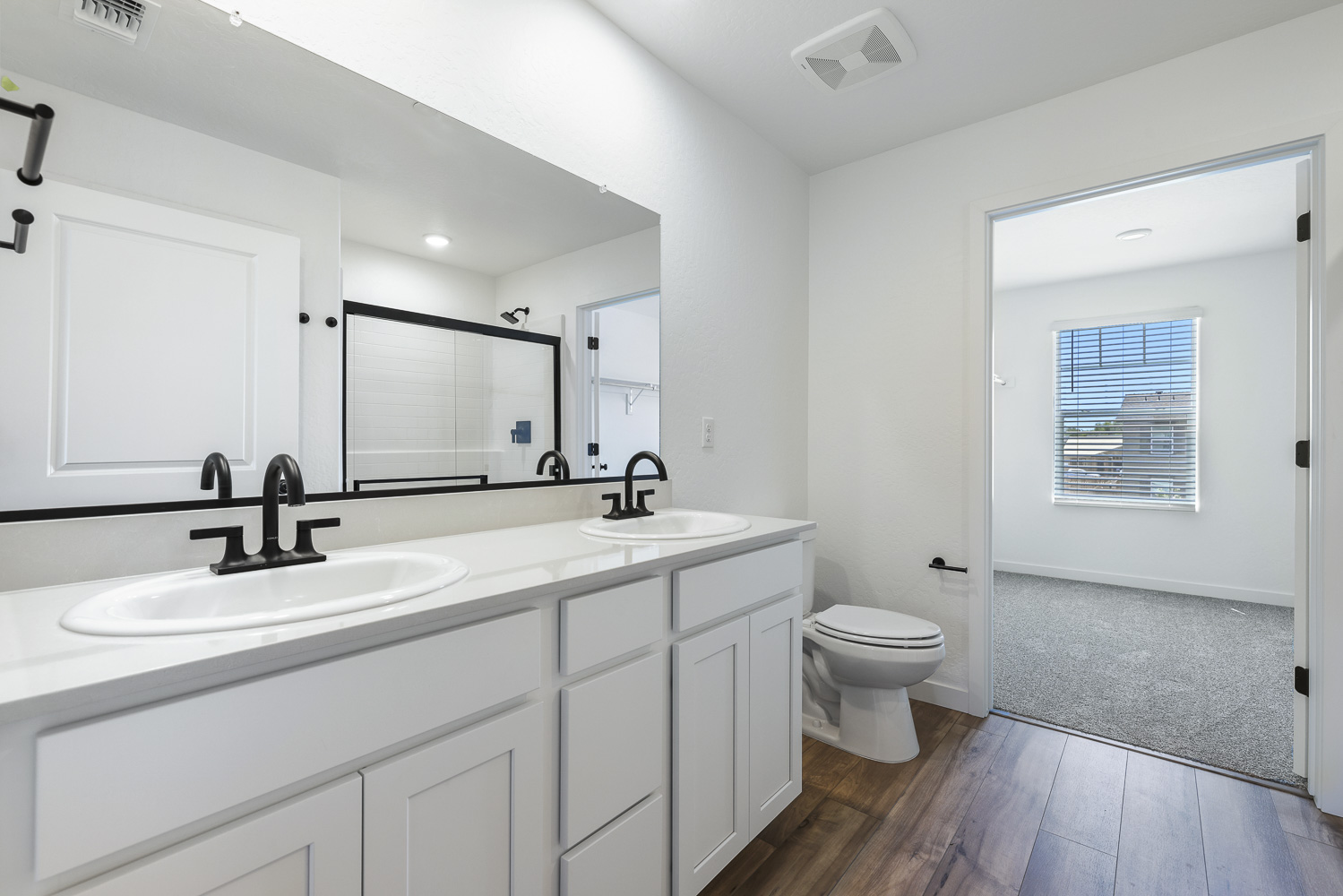 A bathroom with white cabinets.