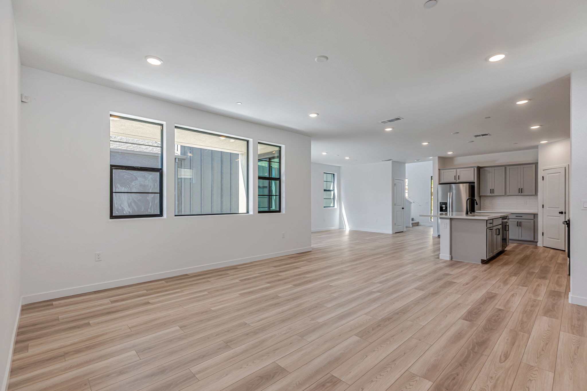 A large empty room with a wood floor and white walls.