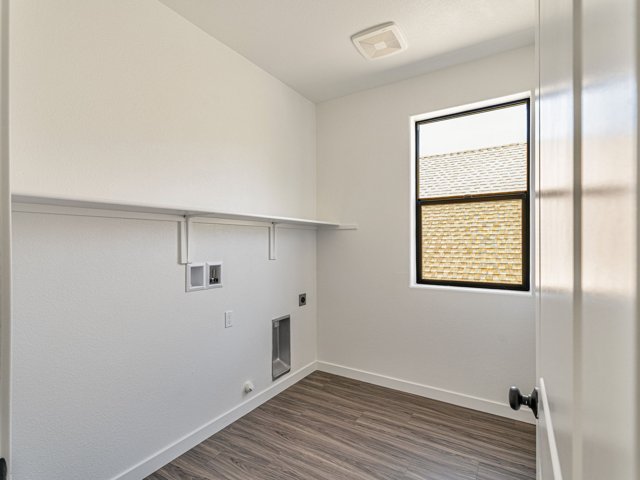 A room with a wood floor and a window.