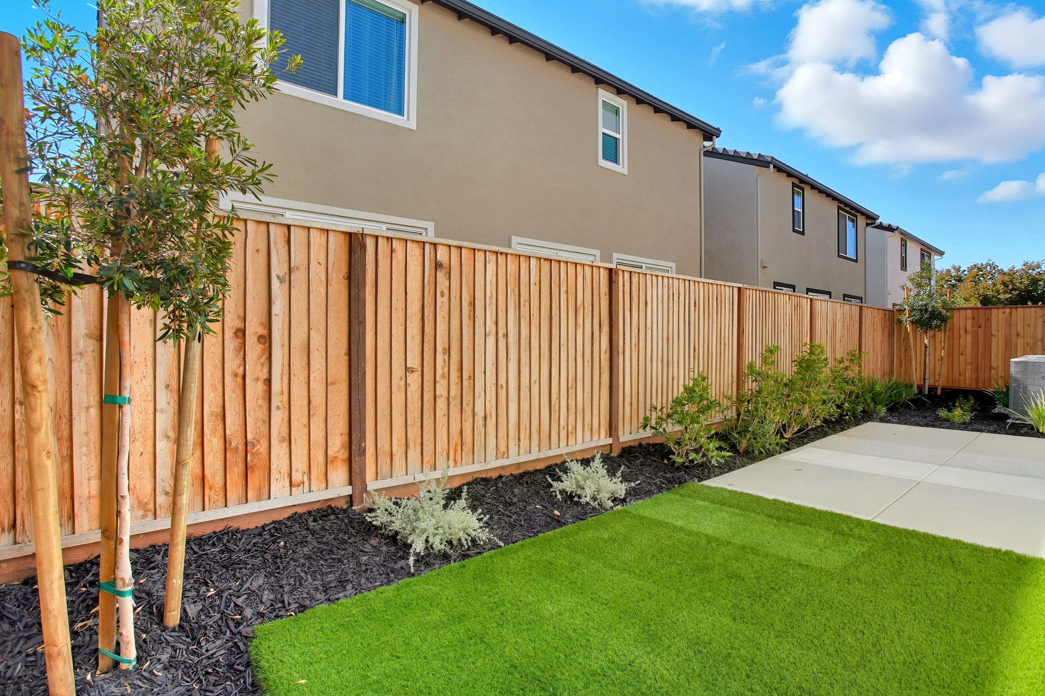 A fenced in yard with a house in the background.